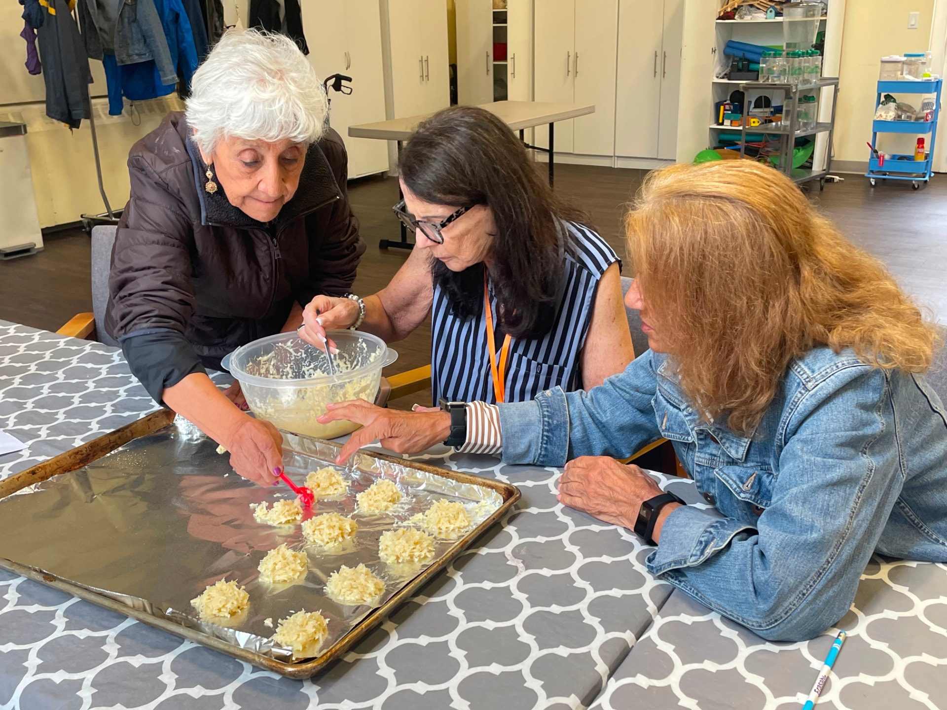 Members spooning macaroons onto a baking sheet together