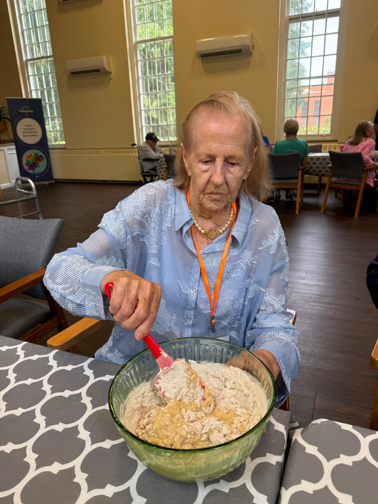 An Evergreen member mixing ingredients by hand at the table