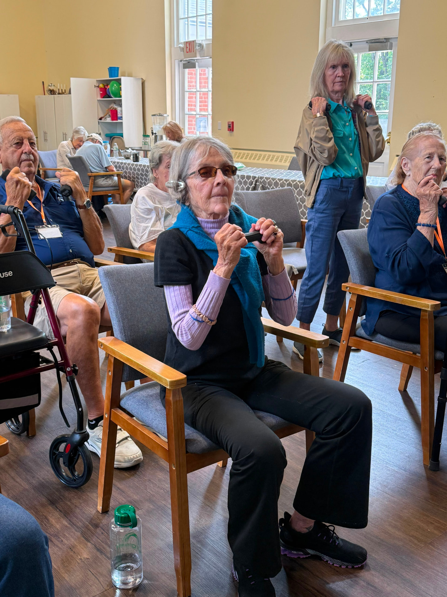 Members working through a seated strength class with hand weights