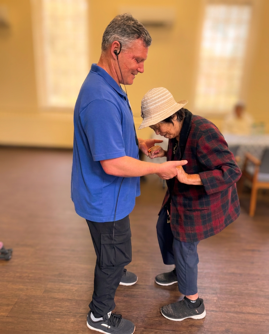 An Evergreen team member steadying a member as she walks across the studio floor