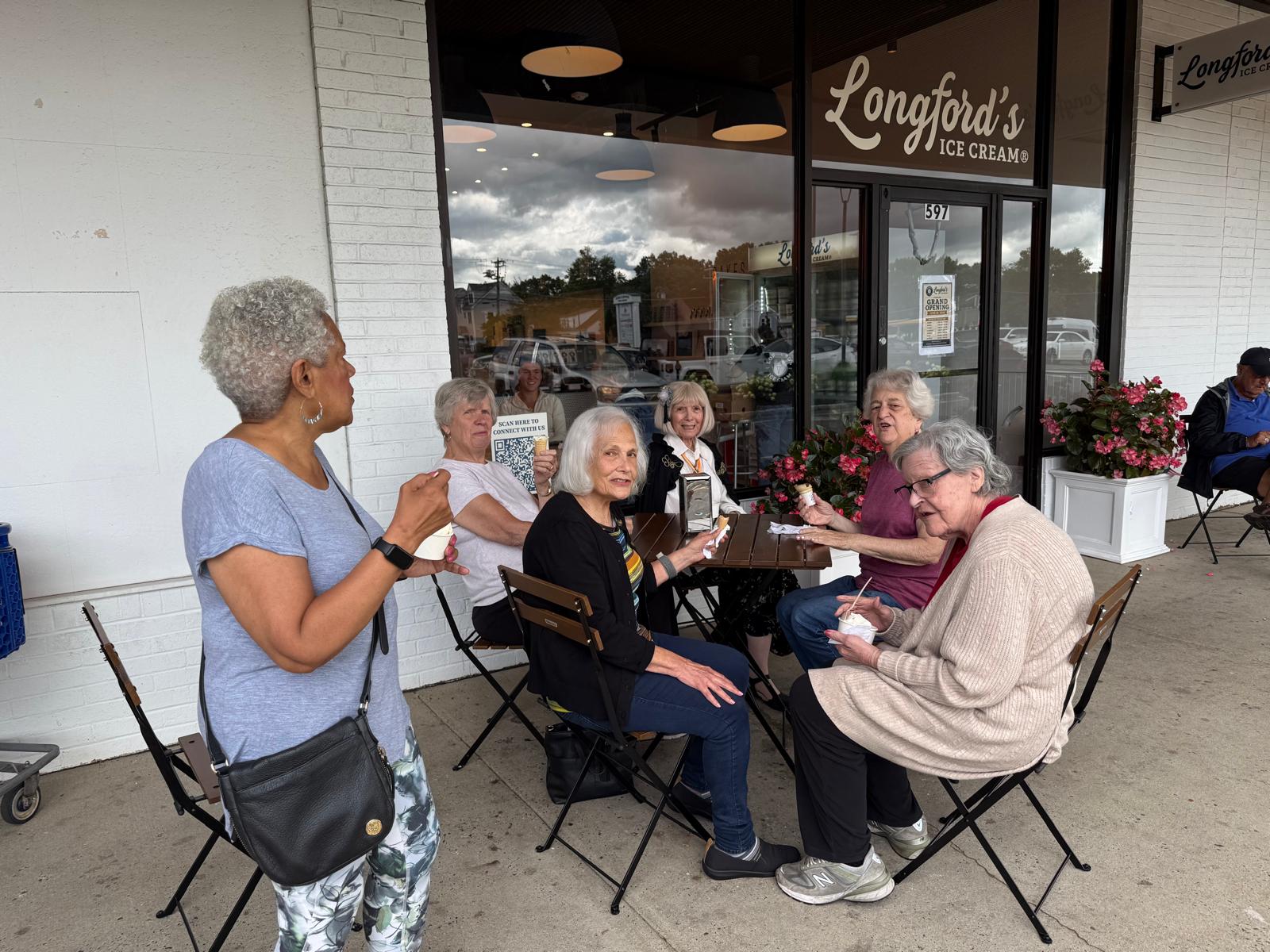 Evergreen members sitting outside an ice cream shop together on an outing