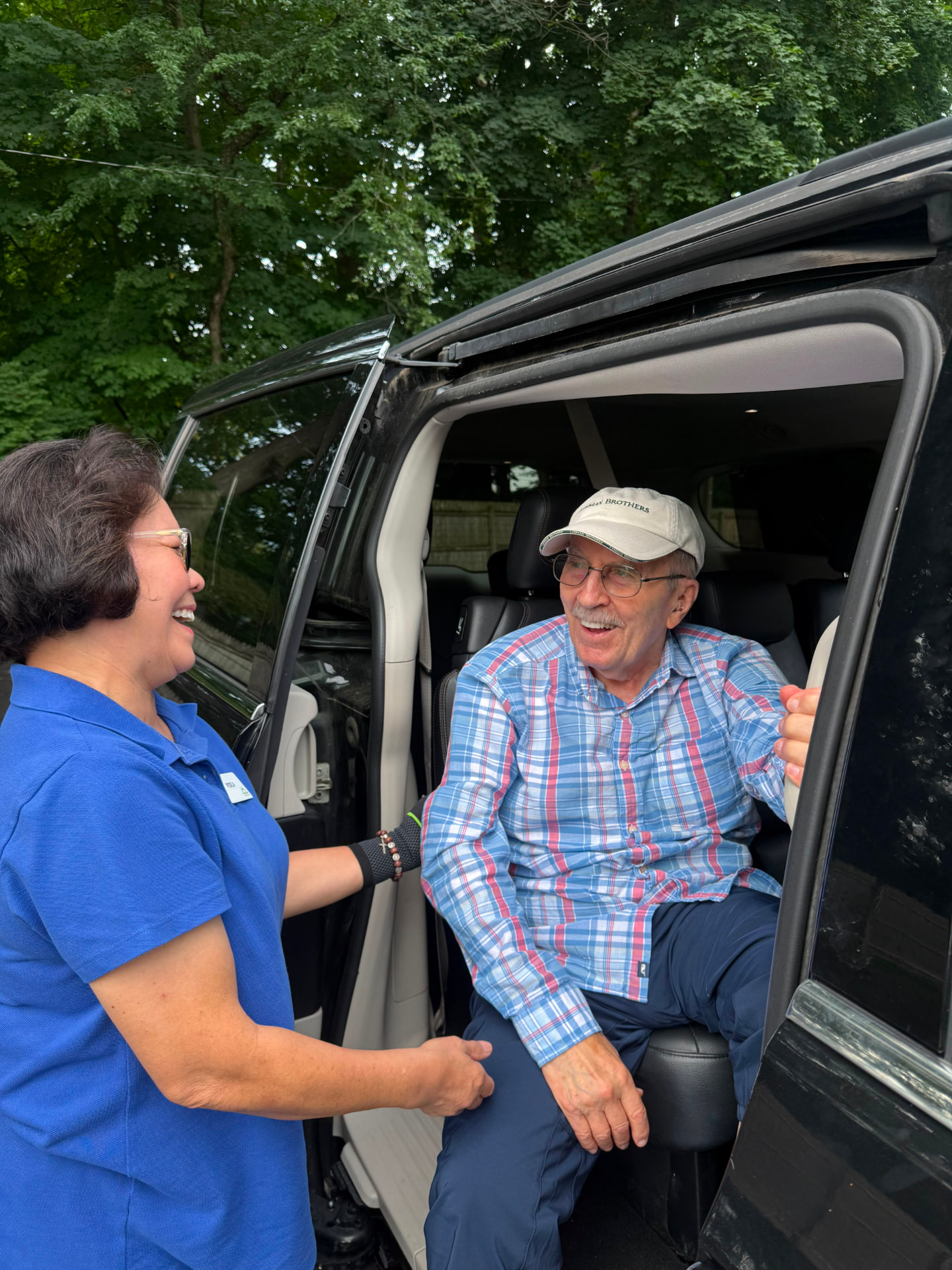 An Evergreen driver sharing a smile with a member through the open van door