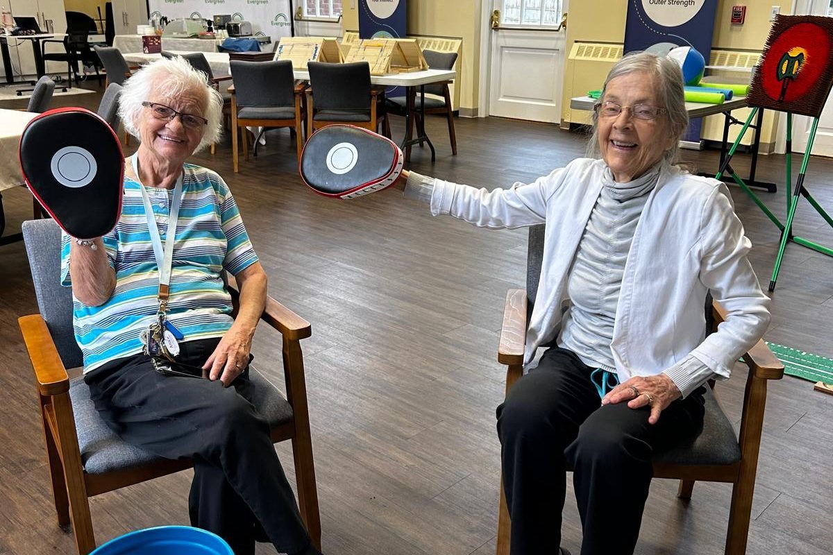 Two Evergreen members laughing together during an afternoon activity